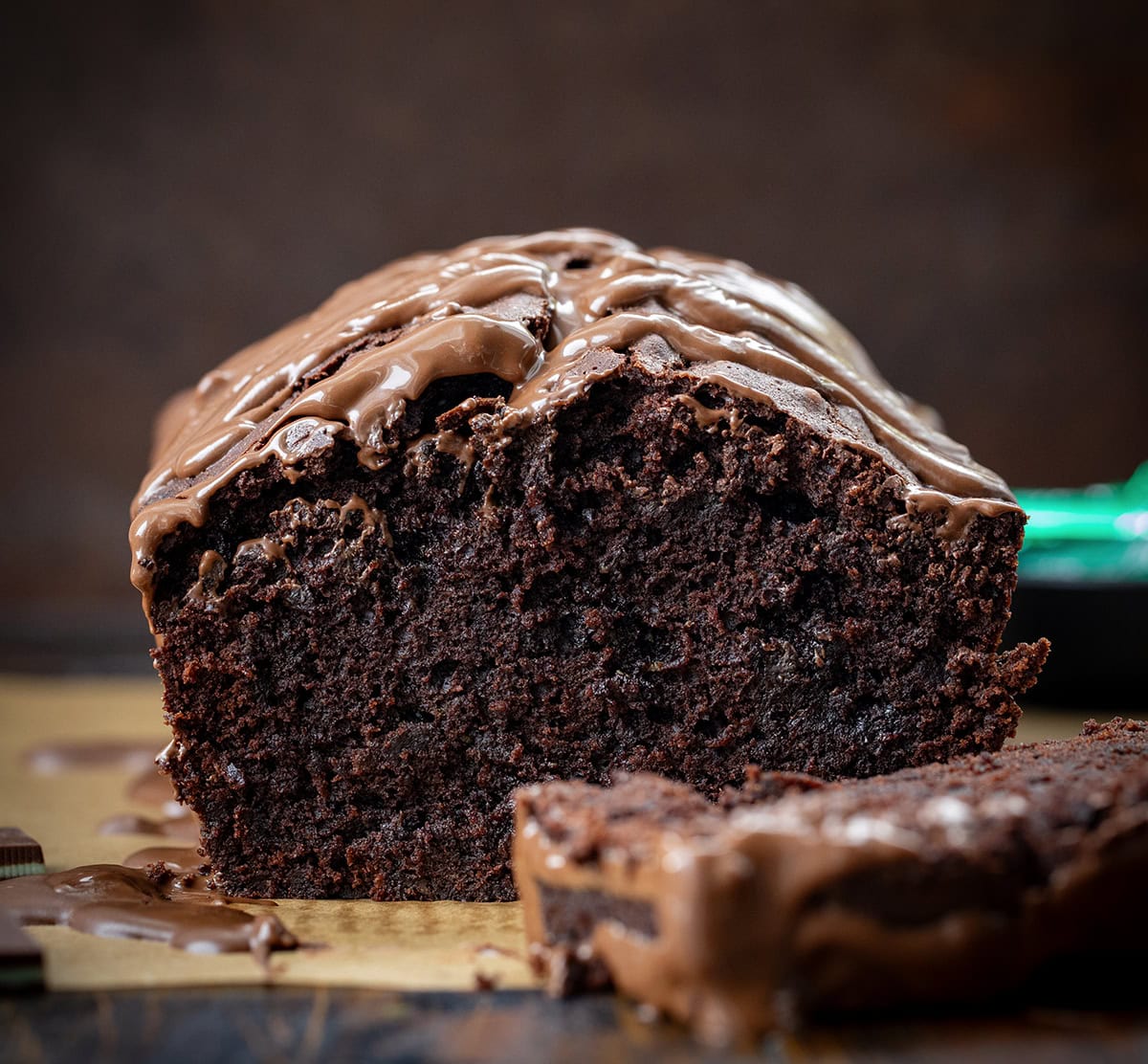 This Peppermint Brownie Bread is a rich and fudgy quick bread that is packed with chocolatey goodness with a refreshing hint of mint. It’s based on my popular brownie bread! Loaf of Peppermint Brownie Bread with pieces cut off laying near the bread.