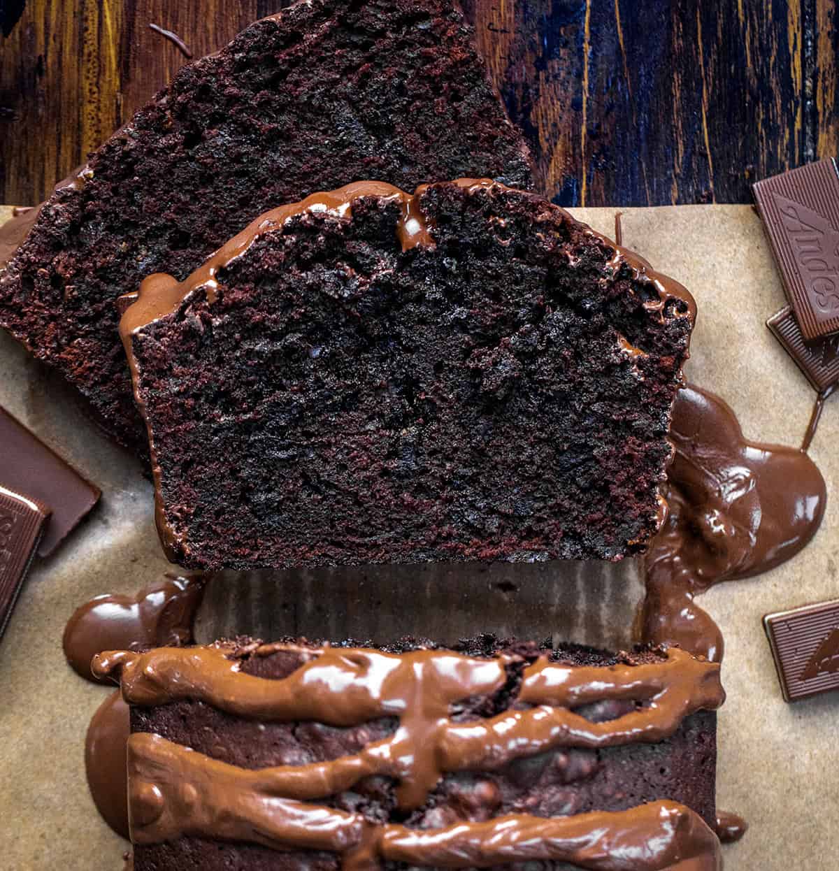 This Peppermint Brownie Bread is a rich and fudgy quick bread that is packed with chocolatey goodness with a refreshing hint of mint. It’s based on my popular brownie bread! Loaf of Peppermint Brownie Bread with some pieces cut and laying flat from overhead.