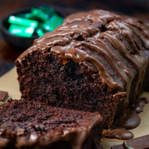 Loaf of Peppermint Brownie Bread with some pieces cut and laying flat but close up with Ande's mints in the background.
