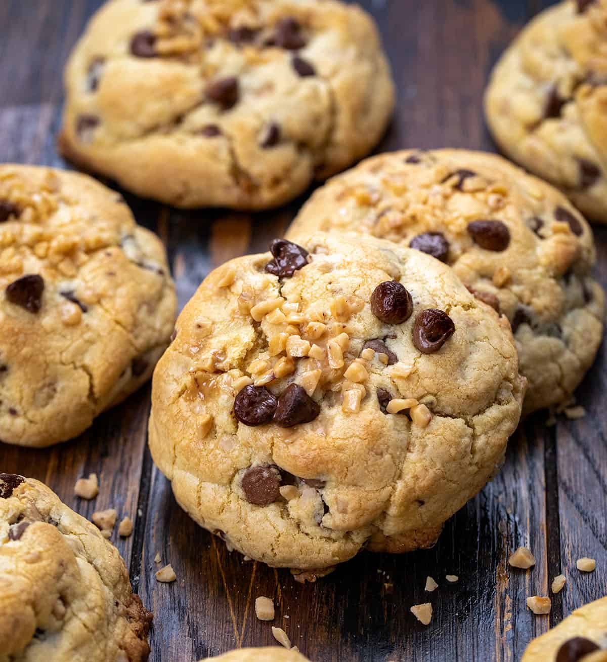 If you love cookies with a soft, chewy center, crispy edges, and a little extra crunch, these Thick and Chewy Chocolate Toffee Cookies are for you. They’re based on my tried-and-true thick and chewy chocolate chip cookies, but with the addition of buttery toffee bits for a sweet, caramelized crunch in every bite! Thick and Chewy Chocolate Toffee Cookies on a wooden table.