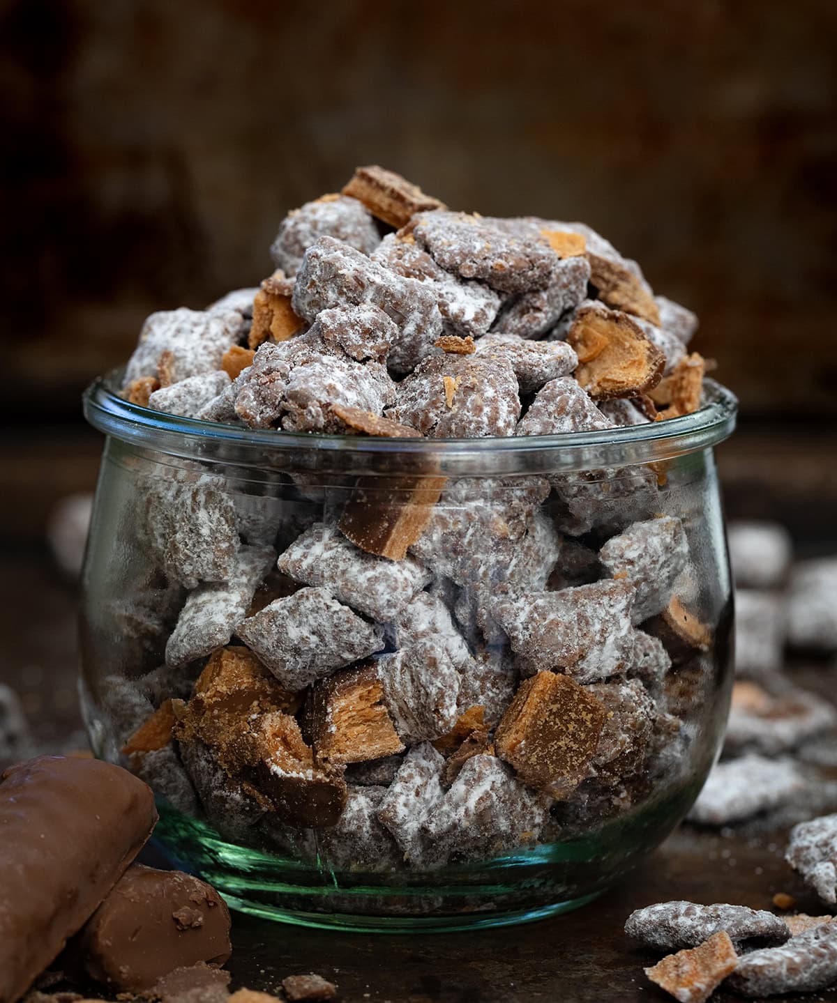 Jar of Butterfinger Puppy Chow on a dark table.