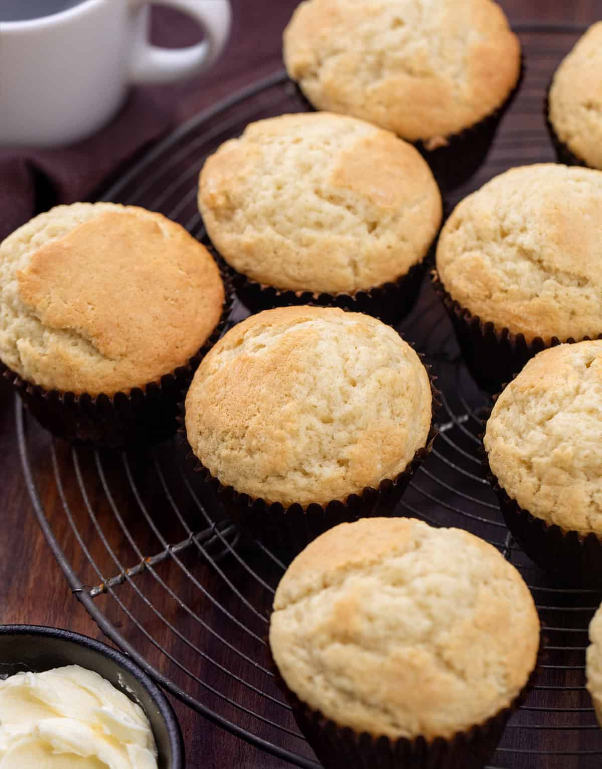 Close up of Buttermilk Muffins on a cooling rack on a wooden table.