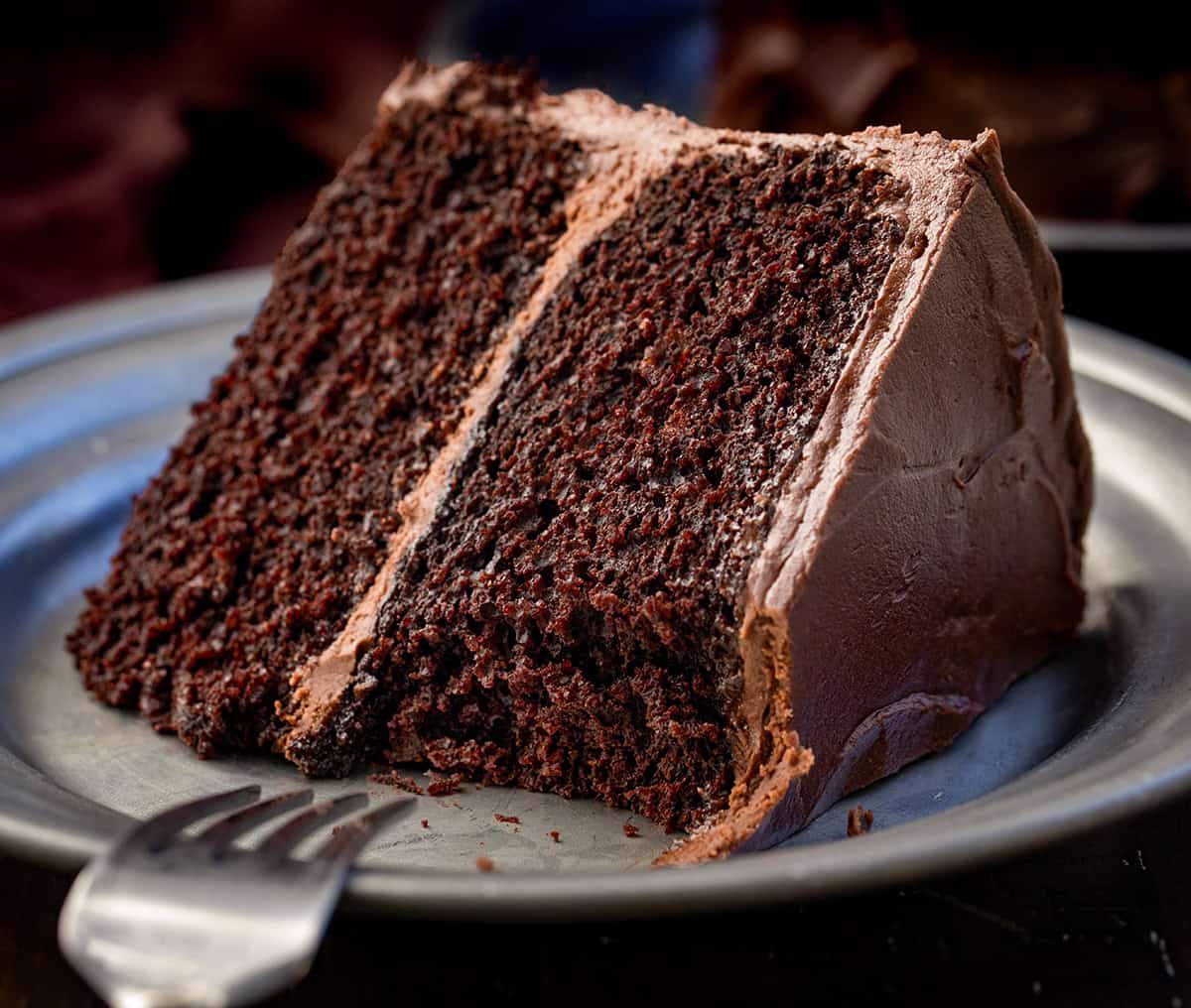 Piece of Devil's Food Cake with a bite removed and fork resting on the plate.