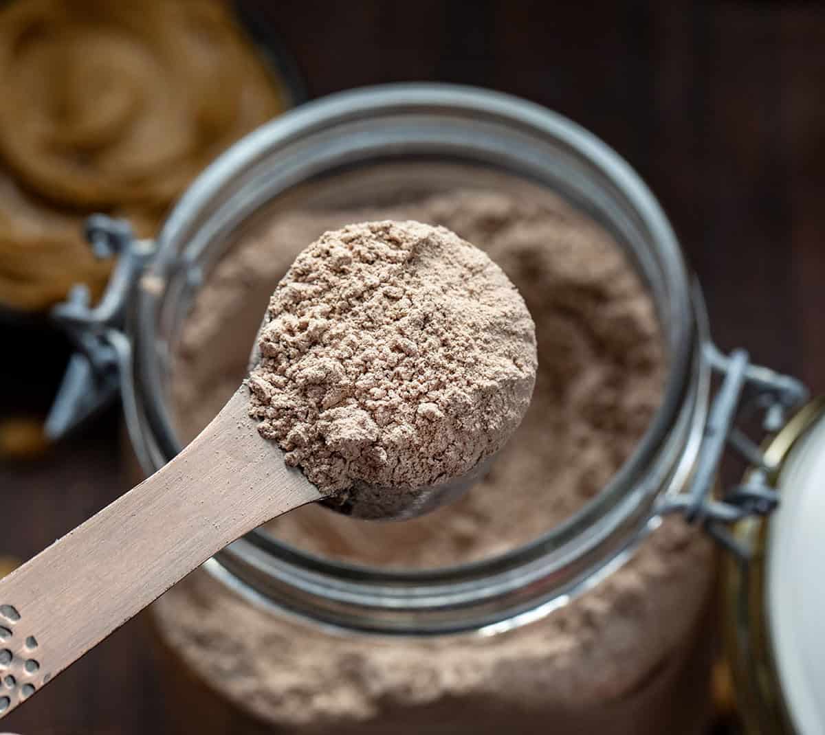 If you love the cozy comfort of homemade hot cocoa but want something a little richer and more fun, this Peanut Butter Hot Cocoa Mix is going to be your new winter favorite. It blends smooth peanut butter flavor with deep, chocolatey warmth! Scoop of Peanut Butter Hot Cocoa Mix being held above the container.