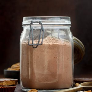 Jar of Peanut Butter Hot Cocoa Mix on a wooden table.