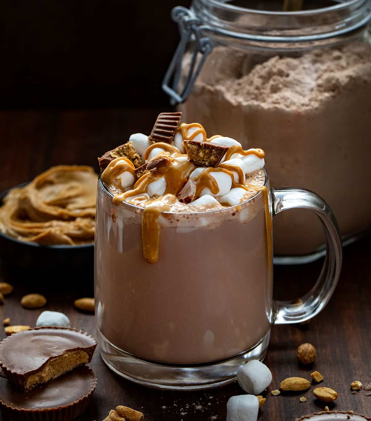 If you love the cozy comfort of homemade hot cocoa but want something a little richer and more fun, this Peanut Butter Hot Cocoa Mix is going to be your new winter favorite. It blends smooth peanut butter flavor with deep, chocolatey warmth! Mug of Peanut Butter Hot Cocoa Mix topped with marshmallows, Reese's peanut butter cups, and drizzled with melted peanut butter.