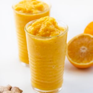 Glasses of Pineapple Ginger Turmeric Smoothie on a white table.