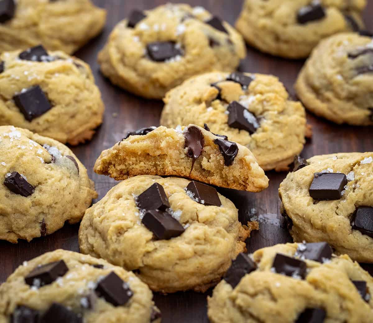 Salted Honey Chocolate Chip Cookies on a dark table with one cookie broke in half.