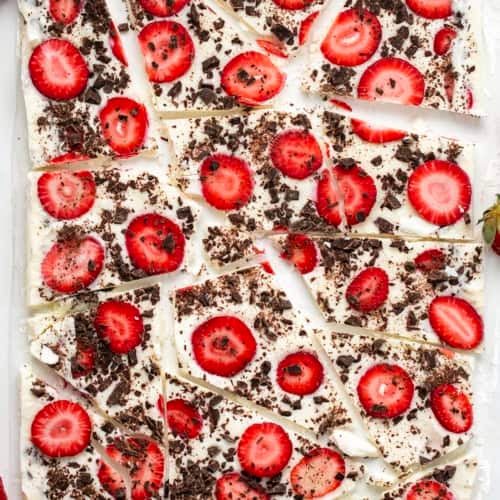 Strawberry Chocolate Yogurt Bark broken into pieces on a white table from overhead.