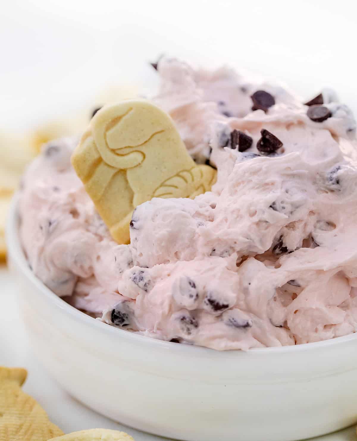 Bowl of Valentine's Booty Dip with animal cracker in it.