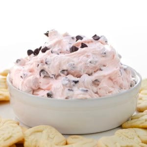 White bowl filled with Valentine's Booty Dip surrounded by animal crackers.