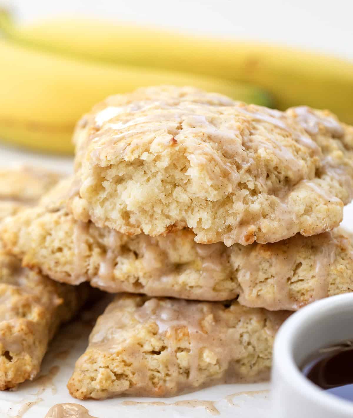 I love these banana scones with maple glaze because they feel like something from a cute bakery case! The edges bake up crisp and golden, and the centers stay soft and tender. The cinnamon maple glaze on top adds sweetness and makes them feel extra special! Torn Banana Scone showing inside texture stacked on other scones.