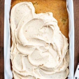 White pan of Browned Butter Banana Bars with Browned Butter Frosting and the frosting is partially covering the bars.