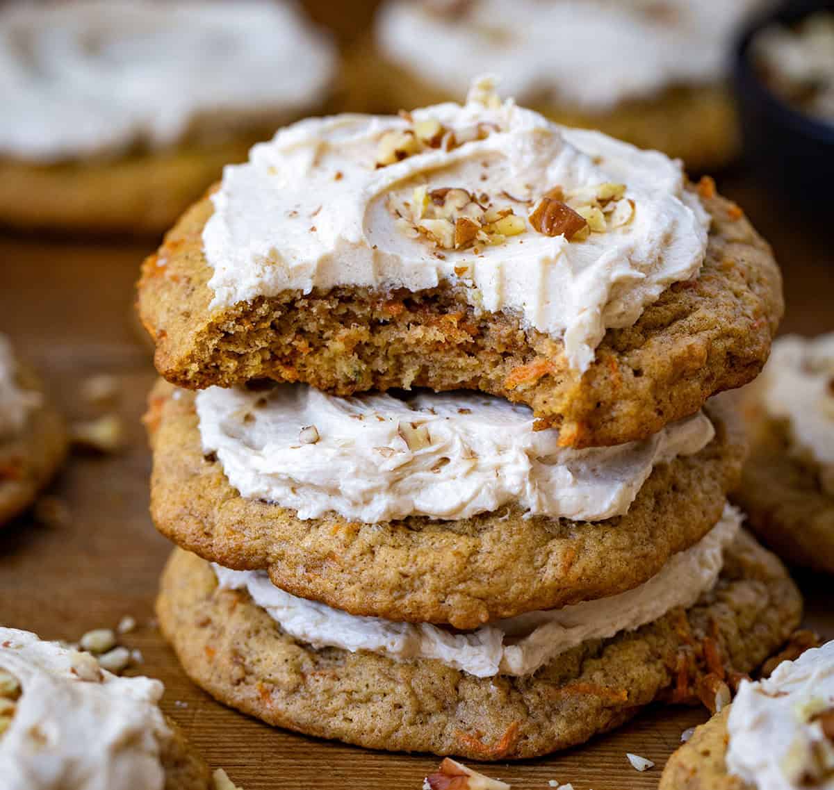 Stack of Carrot Cake Cookies with the top cookie bitten into showing inside texture.