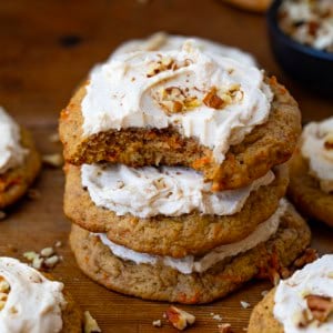 Stack of Carrot Cake Cookies with the top cookie with a bite taken out of it.