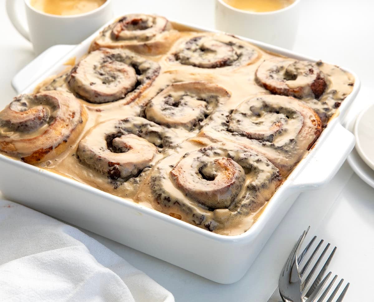 Close up of Chocolate Espresso Rolls on a white table with coffee cups.