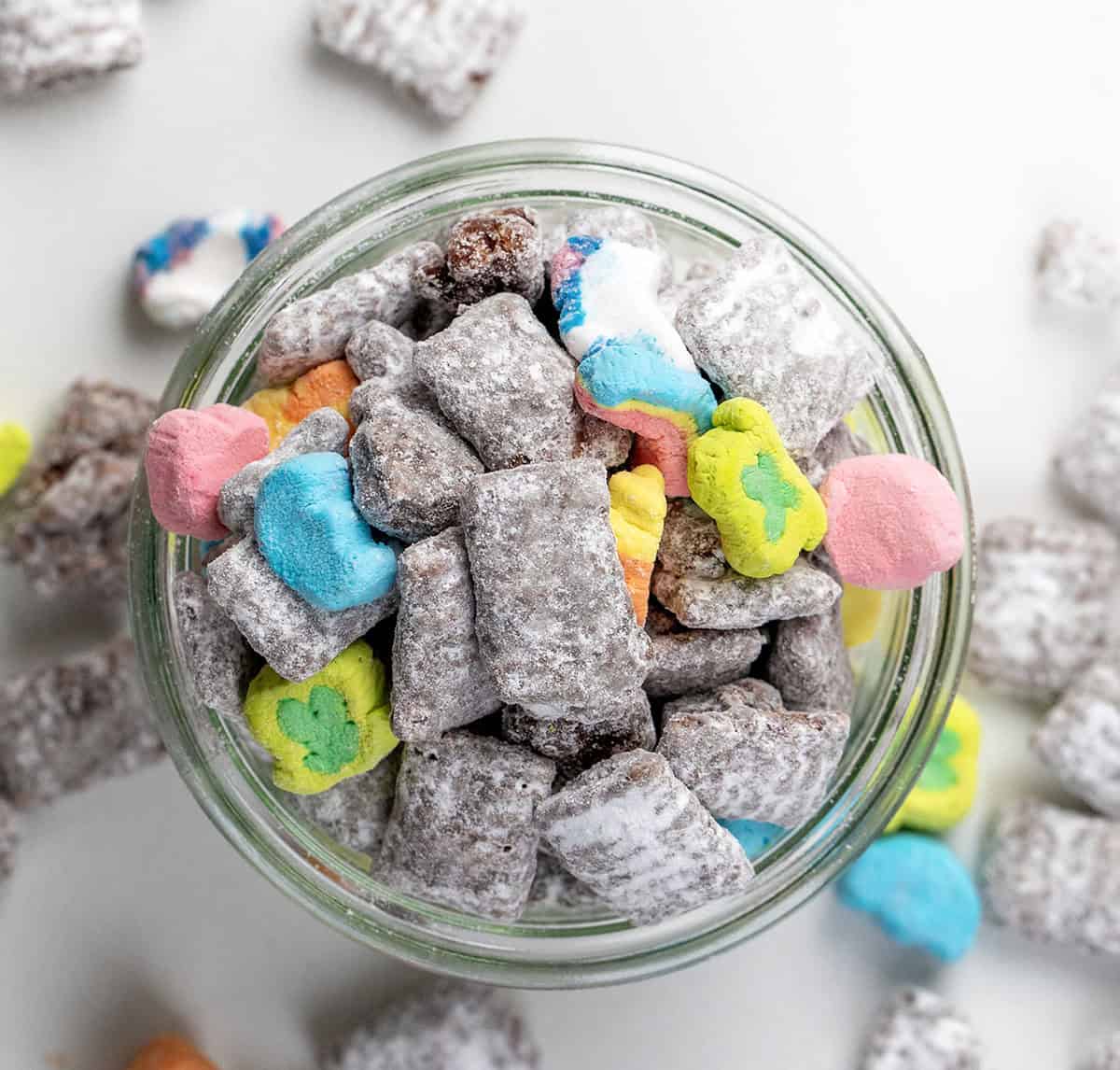 Jar of Lucky Charms Puppy Chow on a white table from overhead.