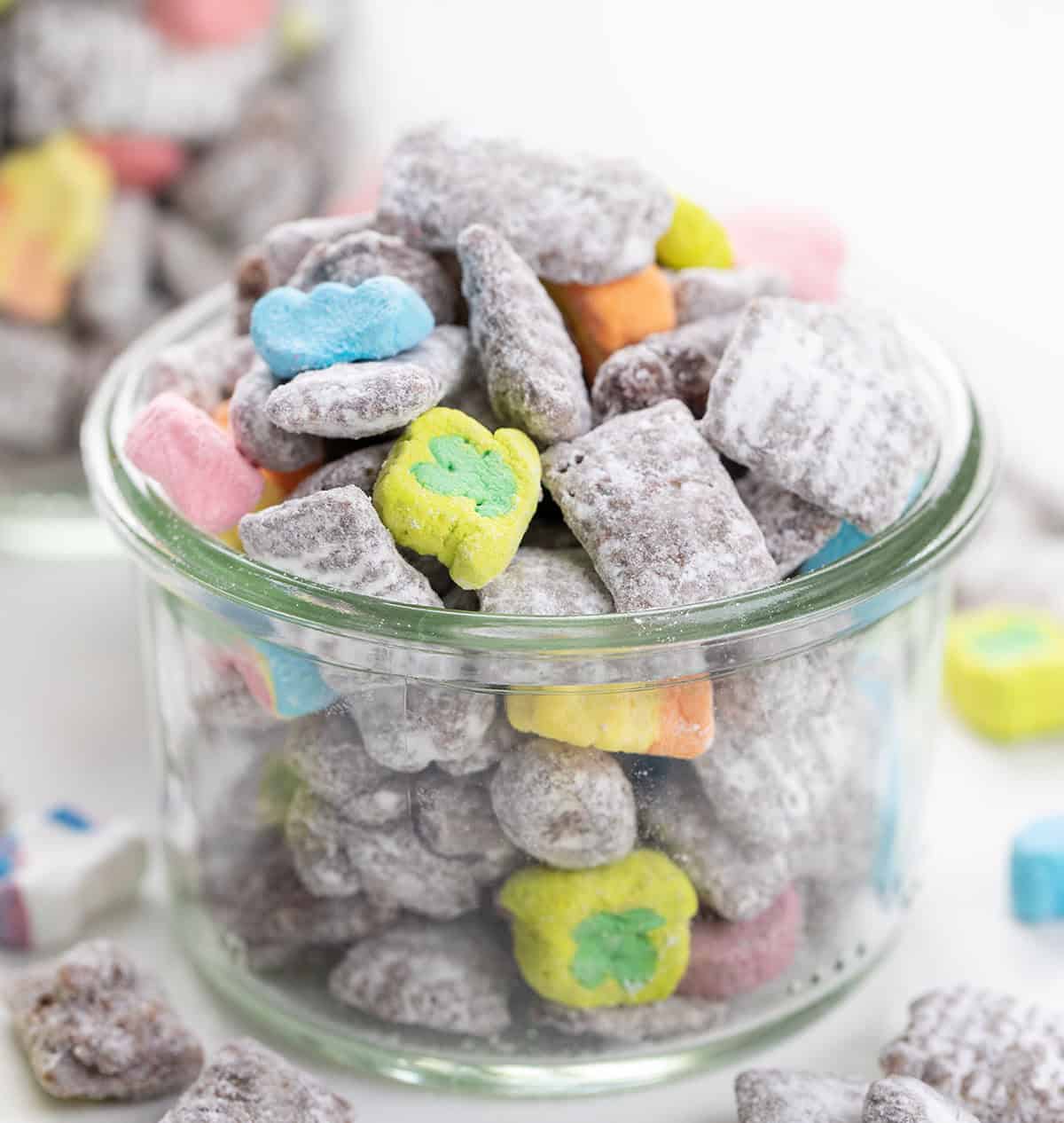 Jar of Lucky Charms Puppy Chow on a white table.