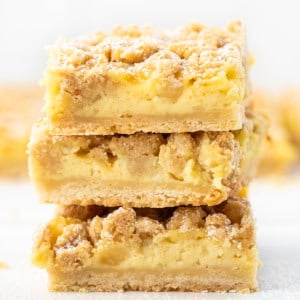 Stack of Vanilla Cream Crumb Bars on a white table close up.