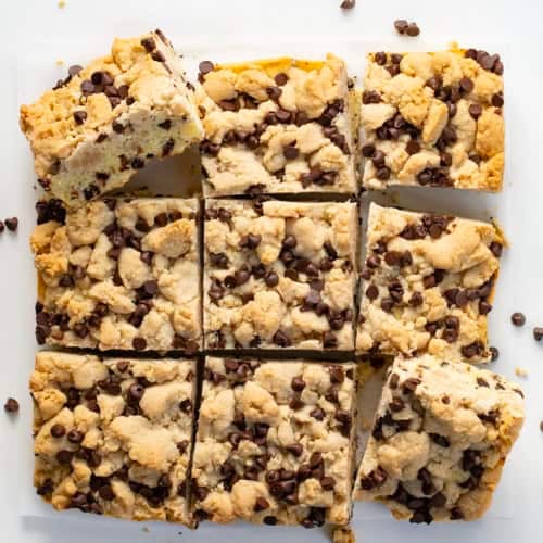 Chocolate Chip Crumb Cake cut into squares on a white table from overhead.