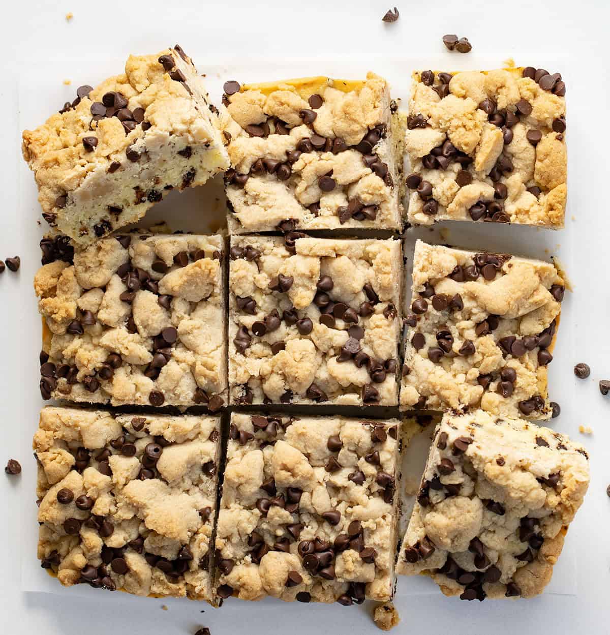 Chocolate Chip Crumb Cake cut into squares on a white table from overhead.