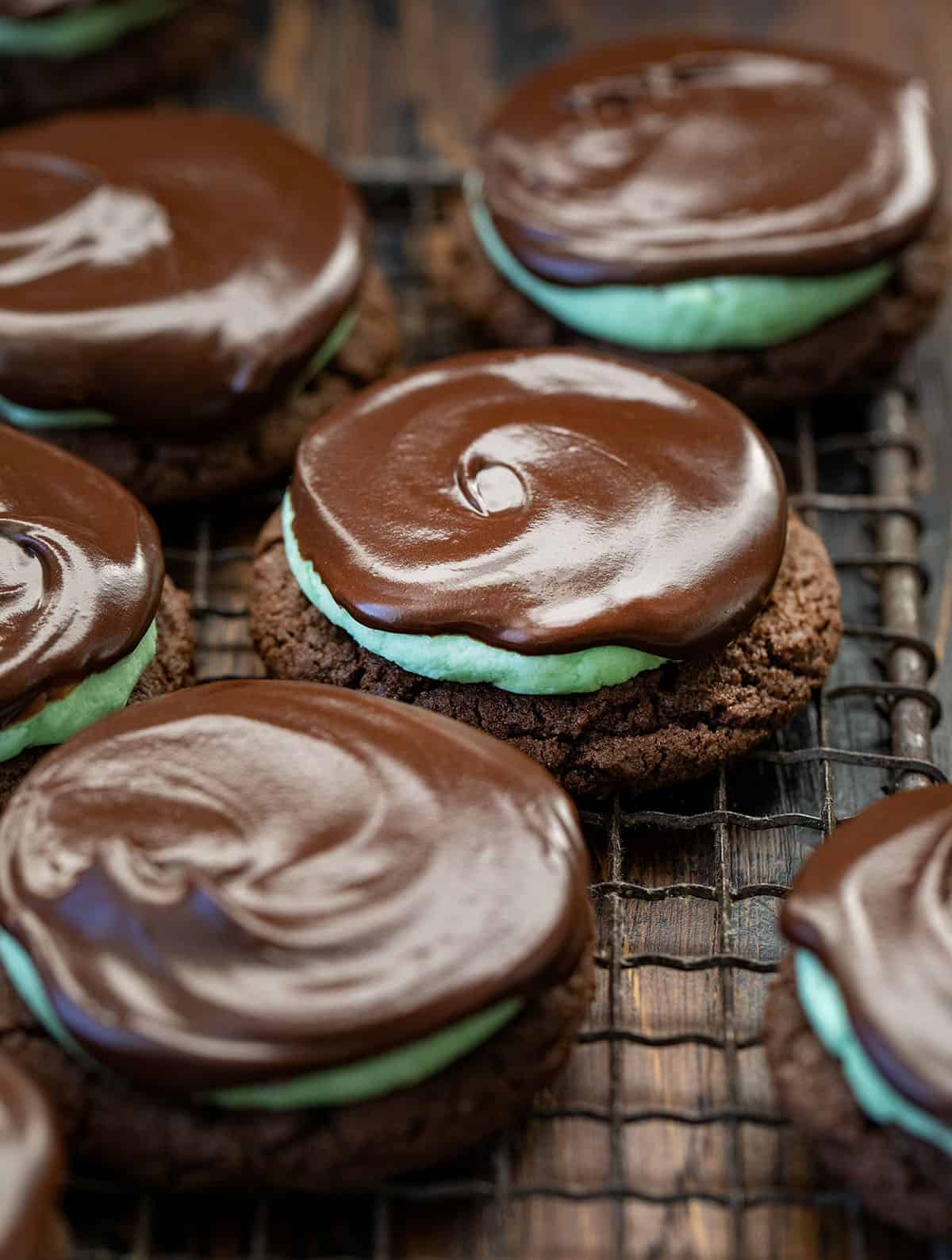 These Chocolate Mint Cookies (Grasshopper Cookies) are a chocolate lover’s dream! Start with soft, cocoa-rich cookies, add a fluffy peppermint filling, and finish with a silky chocolate ganache layer that makes each bite feel extra special! Close up of Chocolate Mint Cookies on a cooling rack.