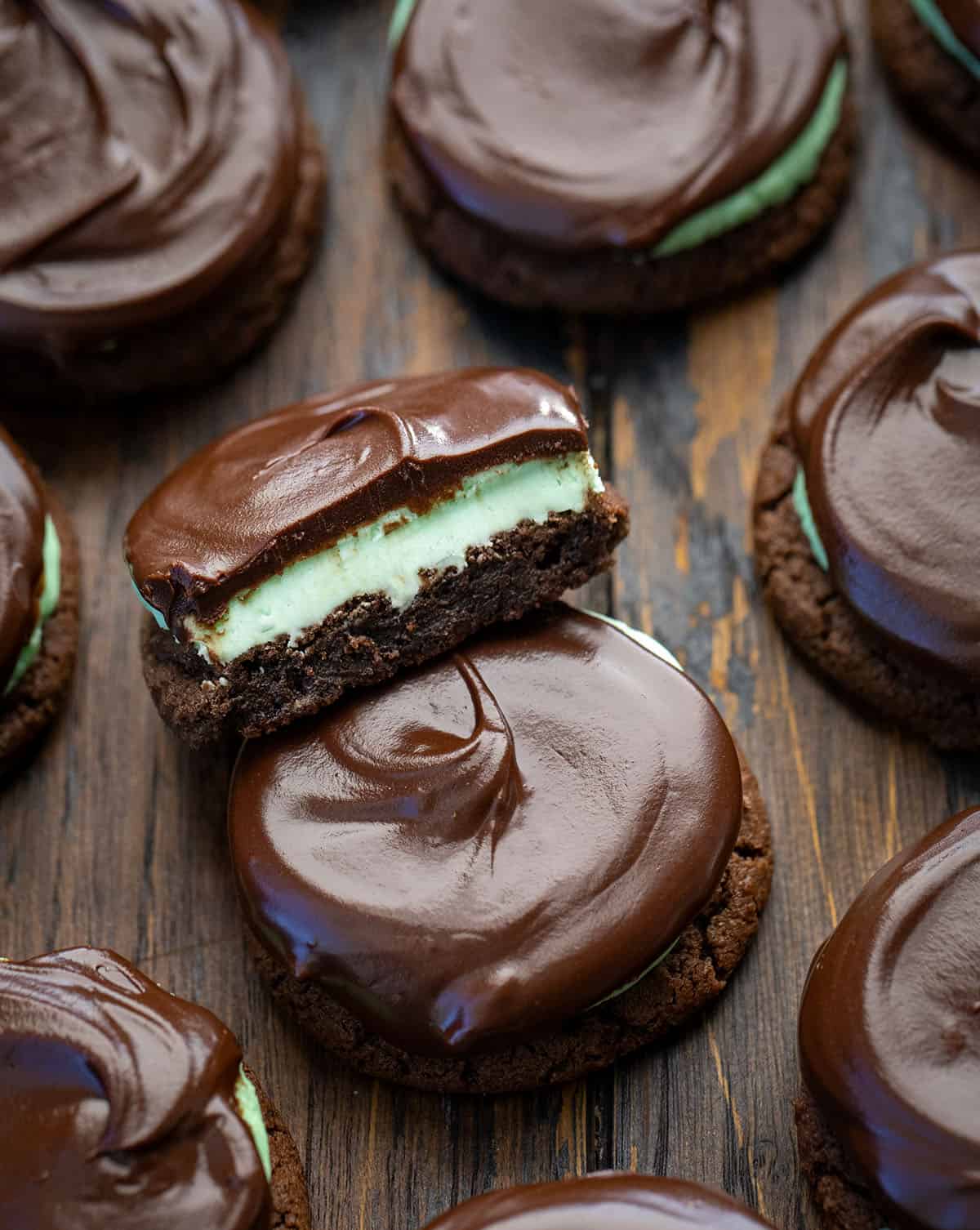 These Chocolate Mint Cookies (Grasshopper Cookies) are a chocolate lover’s dream! Start with soft, cocoa-rich cookies, add a fluffy peppermint filling, and finish with a silky chocolate ganache layer that makes each bite feel extra special! Close up of Chocolate Mint Cookies with one cookie cut in half showing the layer.