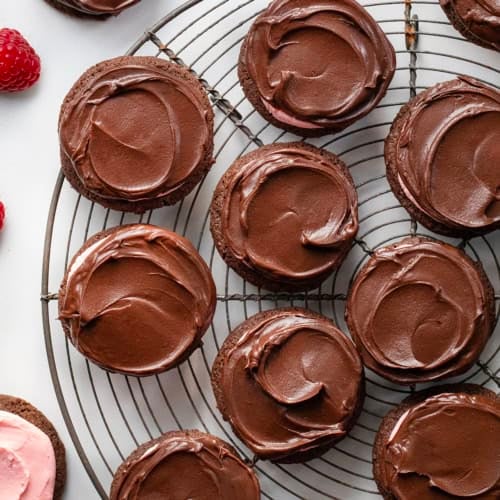 Chocolate Raspberry Cookies on a round cooling rack with fresh raspberries from overhead.