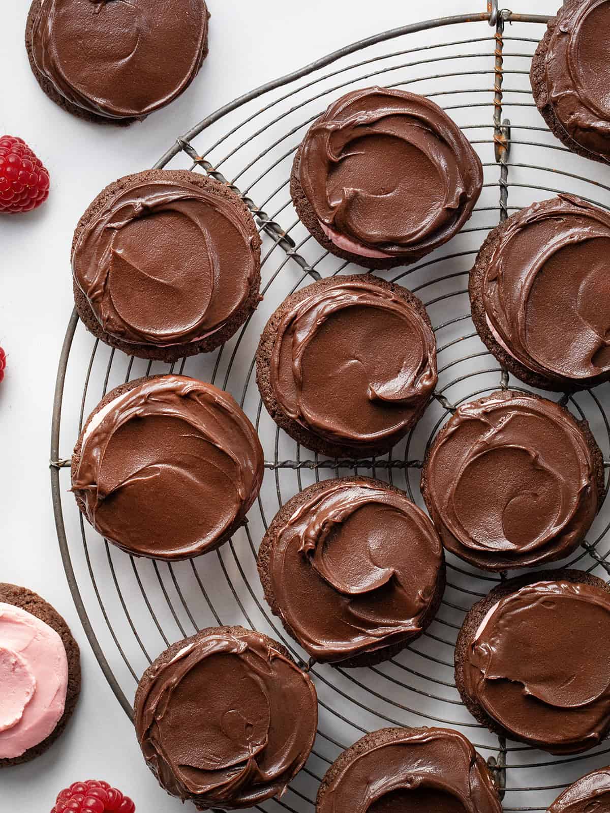 Chocolate Raspberry Cookies on a round cooling rack with fresh raspberries from overhead.