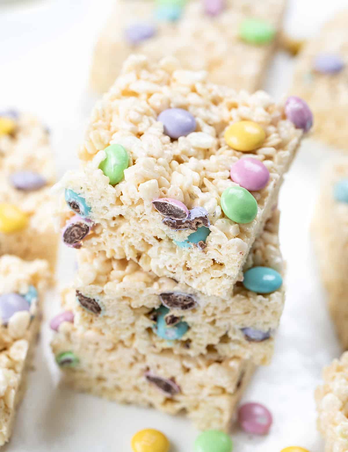 Stack of Easter Rice Krispie Treats on a white table surrounded by more treats.