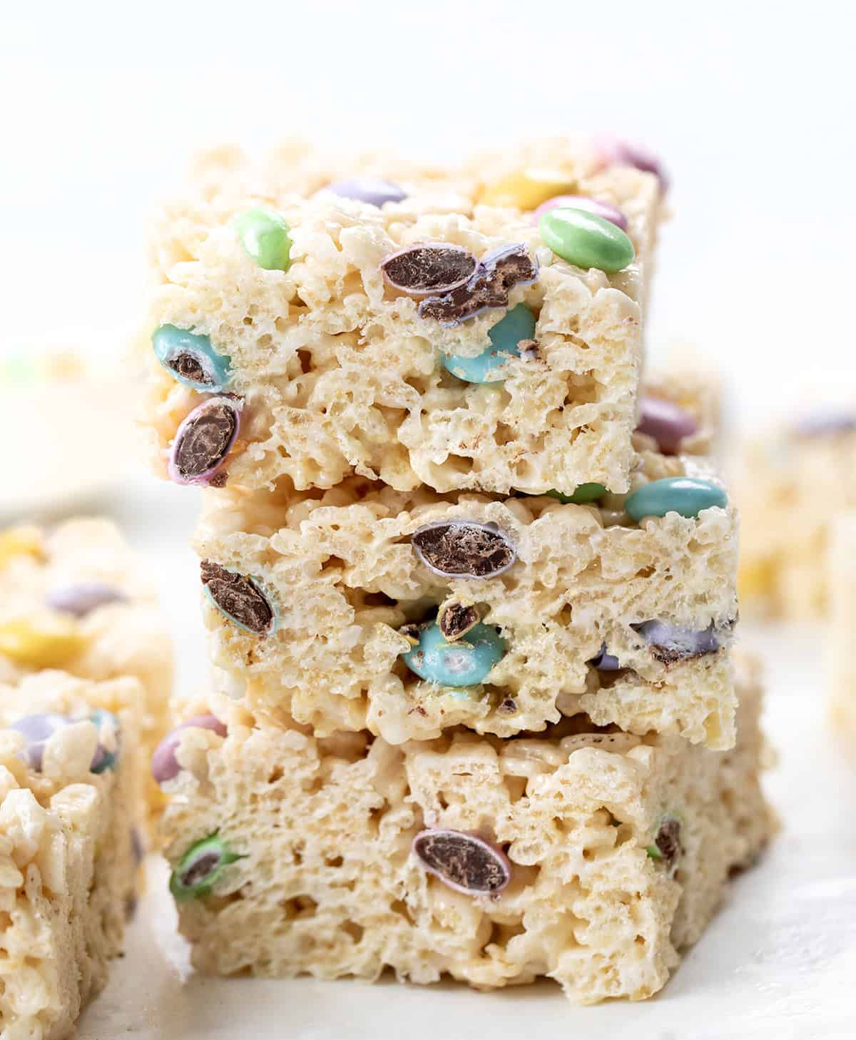 Stack of Easter Rice Krispie Treats cut into squares showing candies inside.