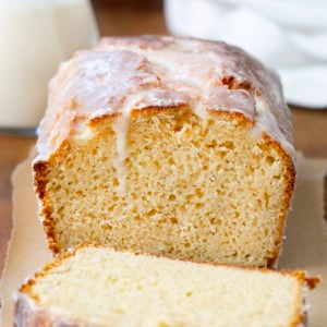 Cut into loaf of Glazed Donut Bread on a wooden table.