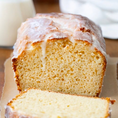 Cut into loaf of Glazed Donut Bread on a wooden table.
