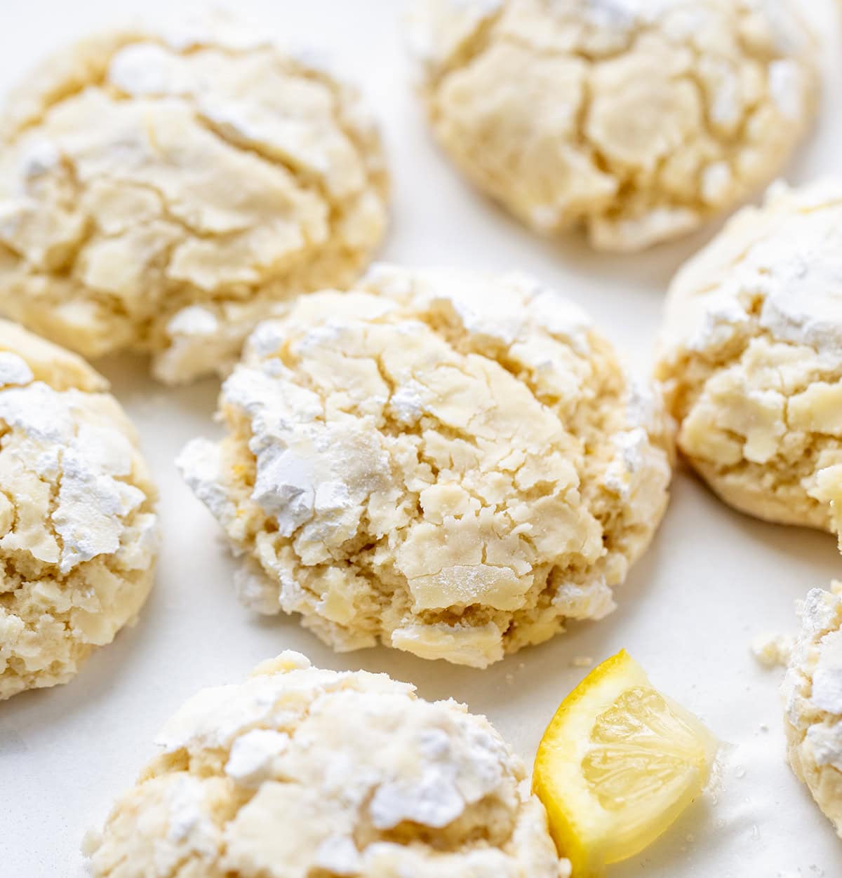 These Lemon Crinkle Cookies are soft, tender, and bursting with bright, fresh lemon flavor. Close up of Lemon Crinkle Cookies on a white table.