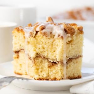 Piece of Sour Cream Coffee Cake with a bite taken out of it and a fork resting on the plate.