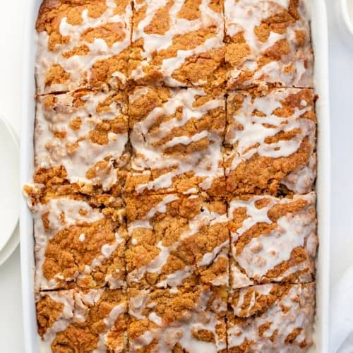 Sour Cream Coffee Cake cut into squares in the pan on a white table from overhead.