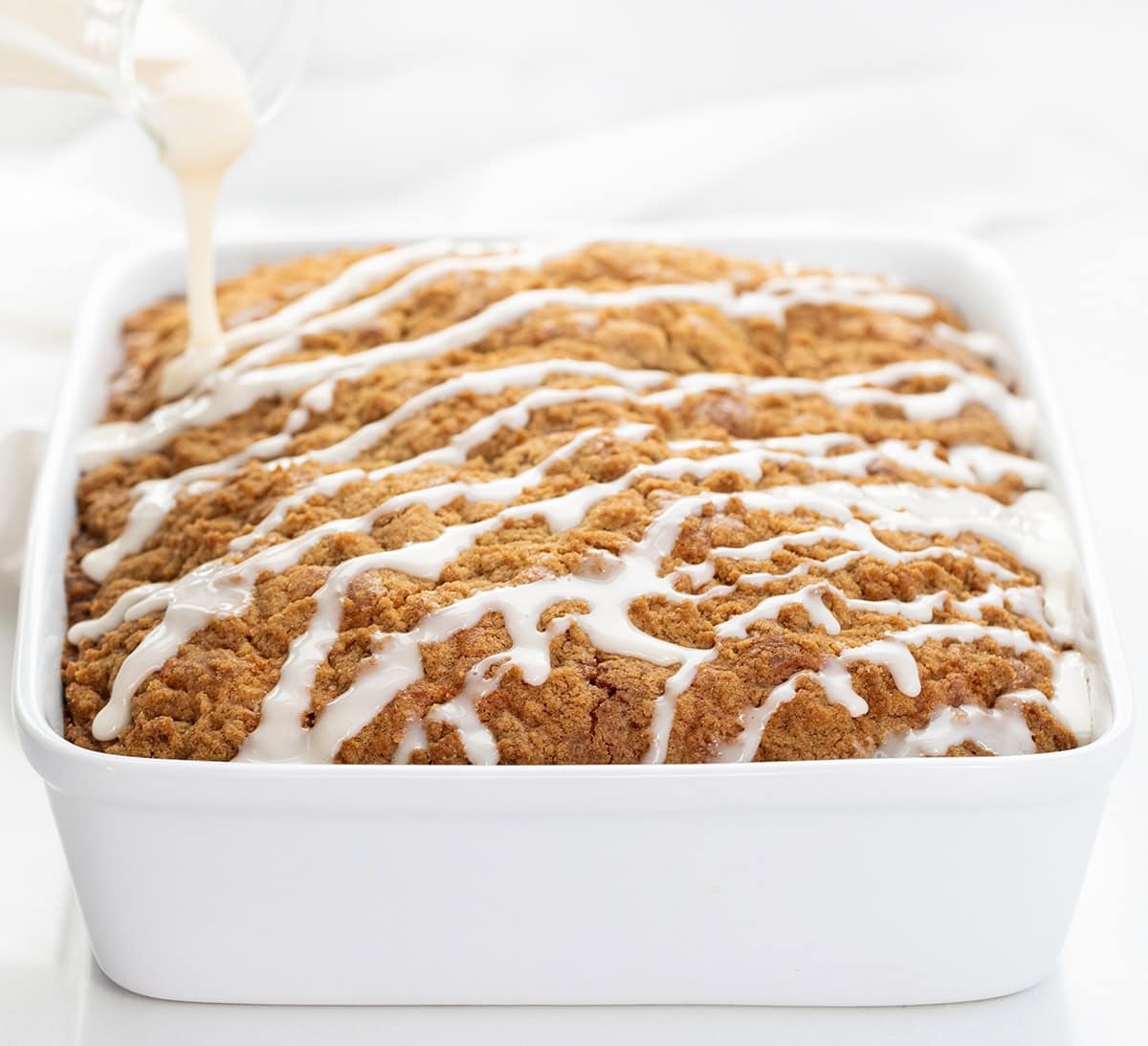 Drizzling glaze over a Sour Cream Coffee Cake.