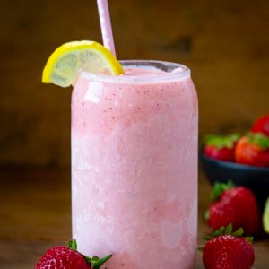 Chilled Strawberry Lemonade Milkshake on a wooden table with fresh strawberry and lemon.