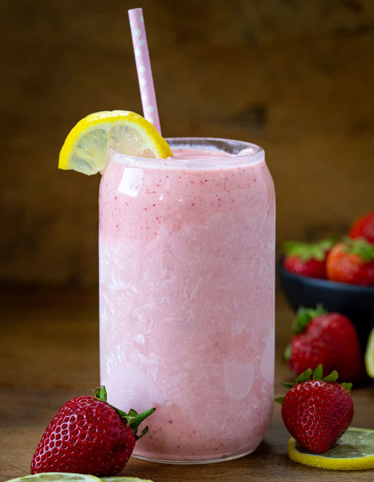 Chilled Strawberry Lemonade Milkshake on a wooden table with fresh strawberry and lemon.