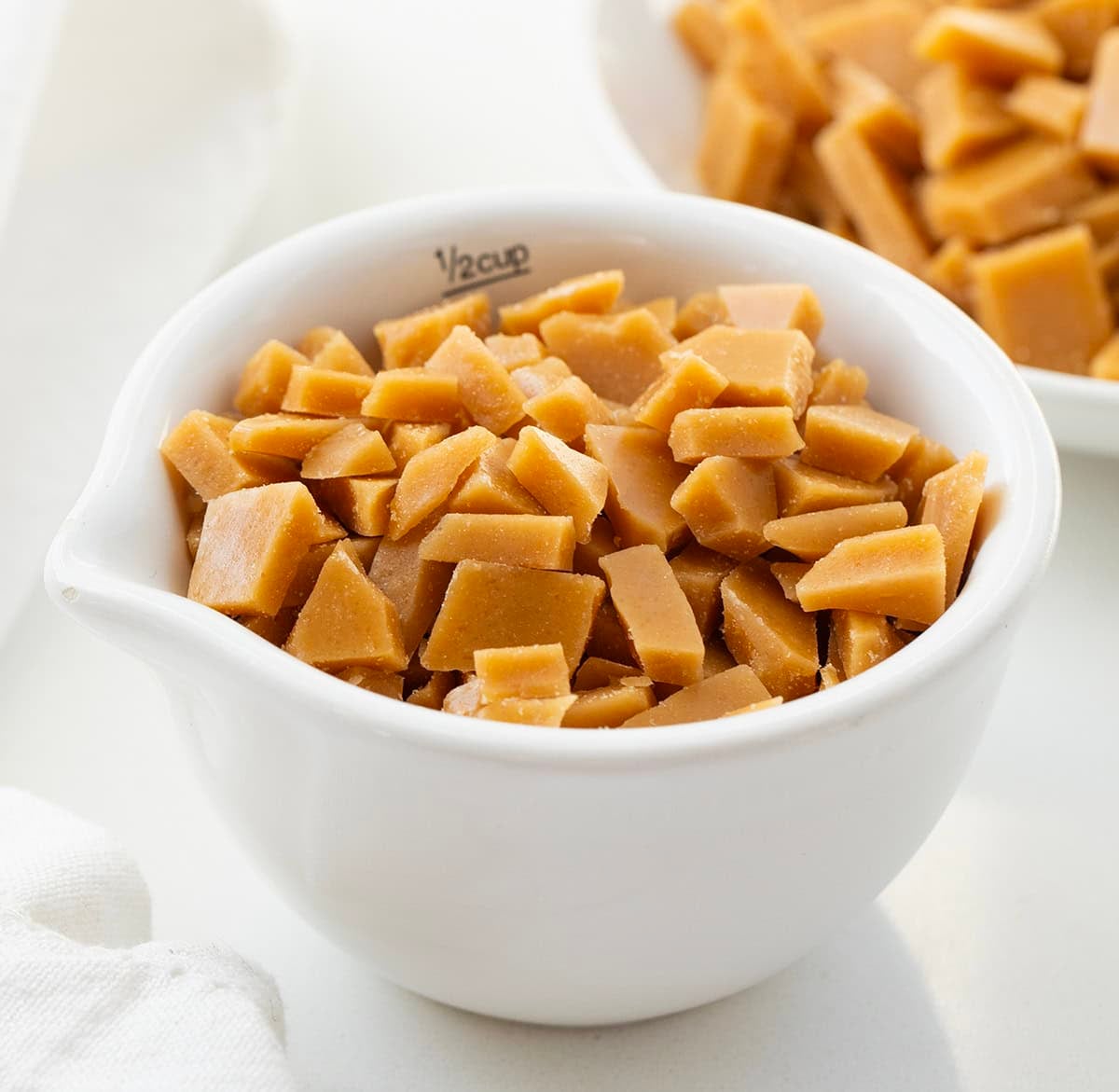 White ceramic measuring cup filled with Toffee Bits.
