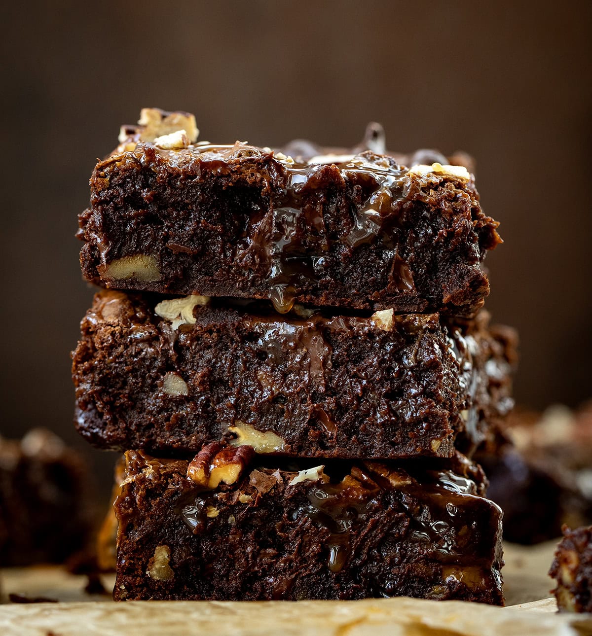 Stack of Turtle Brownies on a dark wooden table.