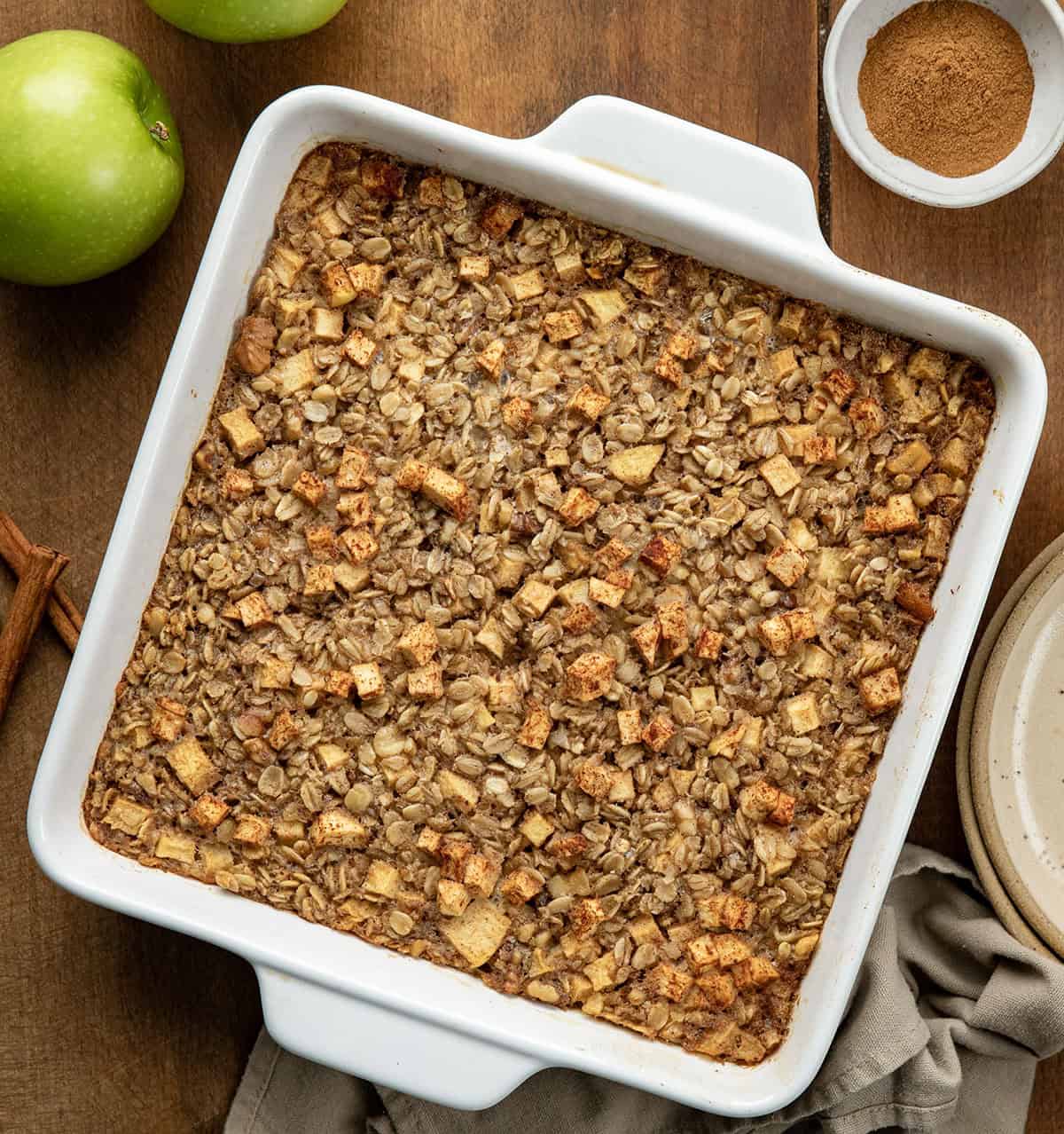 Pan of Apple Cinnamon Baked Oatmeal on a wooden table from overhead.