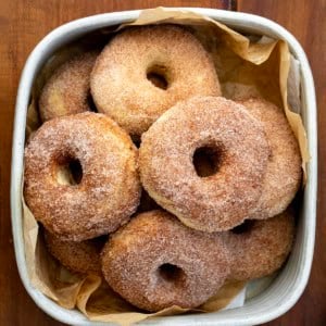 Container of Baked Donuts on a wooden table.