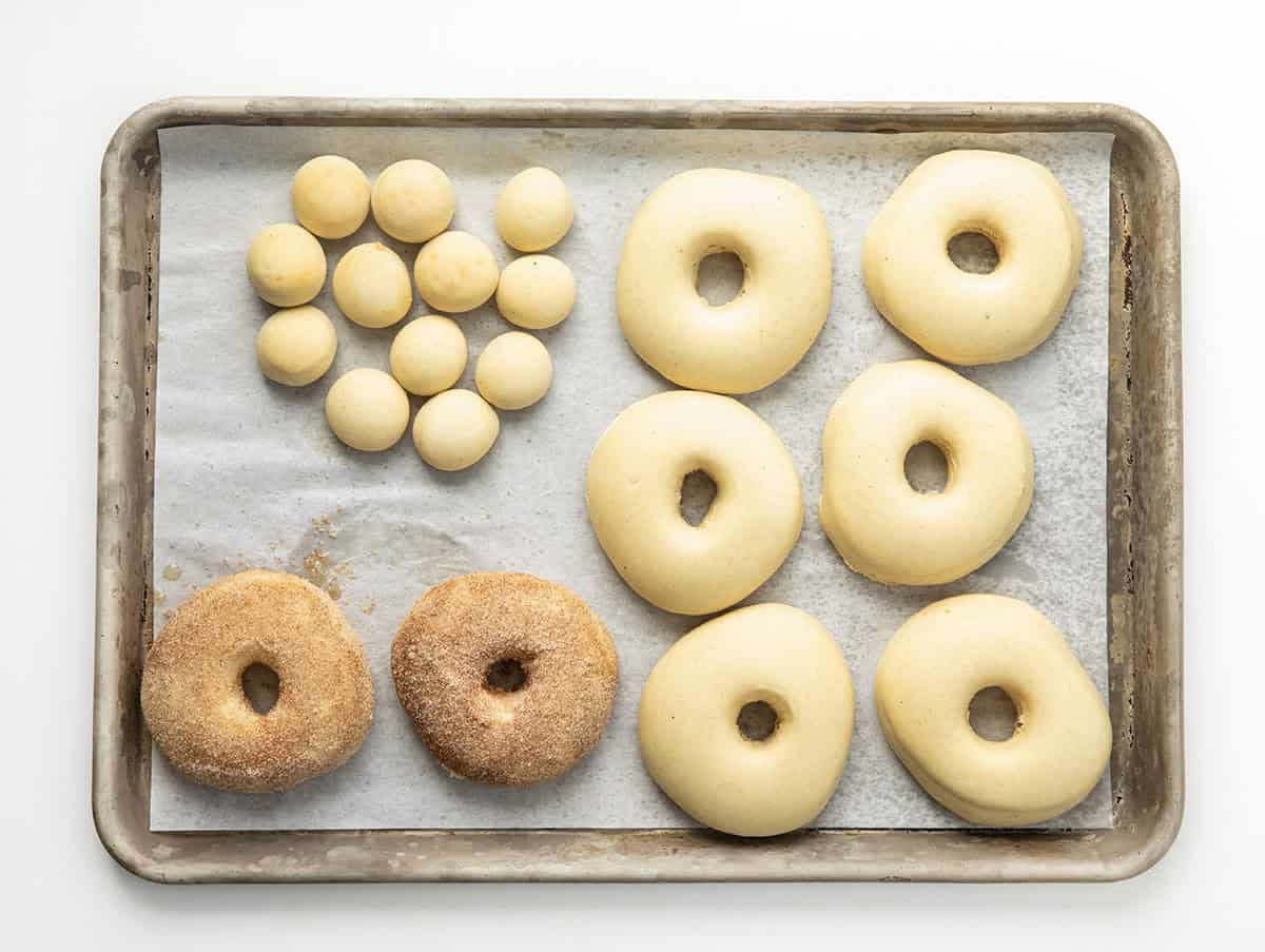 Pan of Baked Donuts with a couple of them with cinnamon sugar on them.