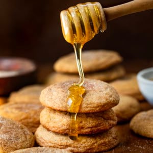Drizzling honey over a stack of Honey Snickerdoodles.
