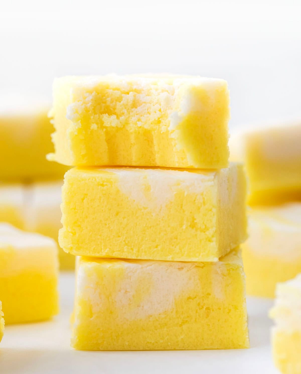 Stack of Lemon Creamsicle Fudge with the top piece having a bite taken out of it.