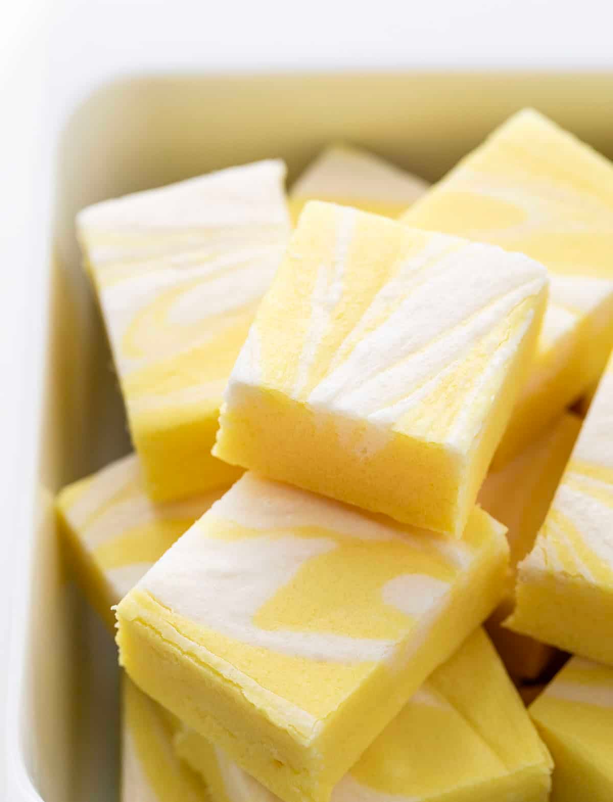 Lemon Creamsicle Fudge stacked in a white container.