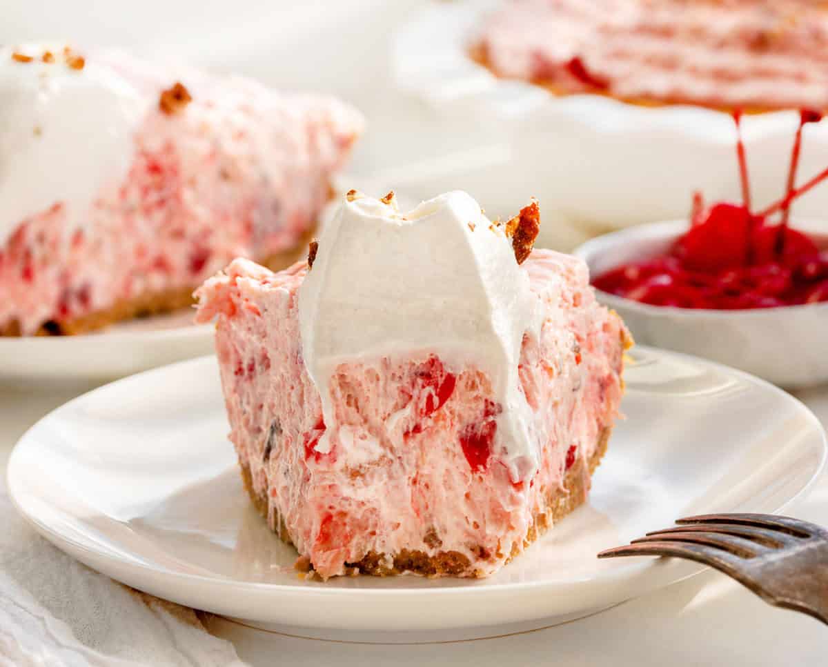 Slice of Millionaire Pie on a white plate with a bite removed and fork resting on the plate.