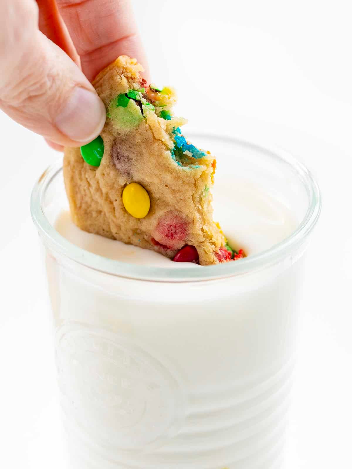 Dipping a half eaten Mini M&M Cookie into milk.