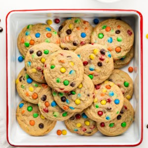 Mini M&M Cookies in a white square pan on a white table from overhead.